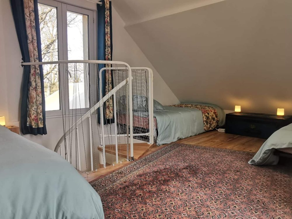 La Mezzanine : un grand lit et deux lits simples sous les toits, escalier en colimaçon